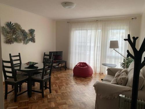 a living room with a table and a couch at Garden Apartment, great for couple - Ponta Delgada in Ponta Delgada
