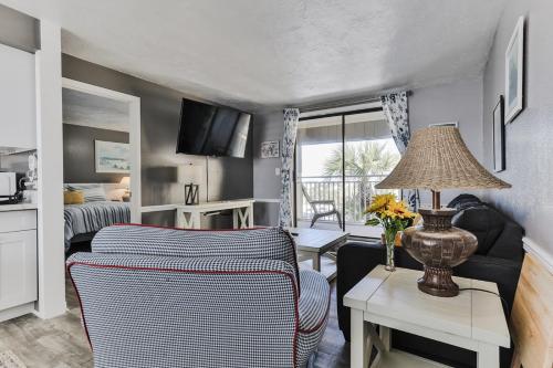 a living room with a couch and a table with a lamp at Coastal Waters in New Smyrna Beach