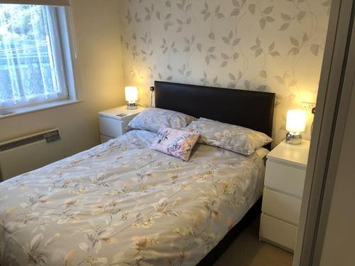 ein Schlafzimmer mit einem Bett mit zwei Nachttischen und zwei Lampen in der Unterkunft Marine House Holiday Home in Portree