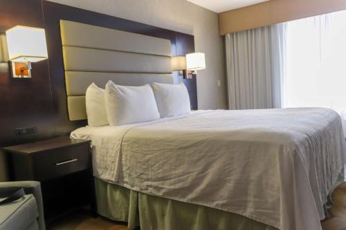 a hotel room with a large bed with white sheets at Best Western Plus Silverdale Beach Hotel in Silverdale