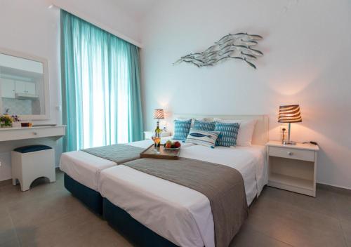 a bedroom with a large bed and a large window at Iris Skiathos in Skiathos Town