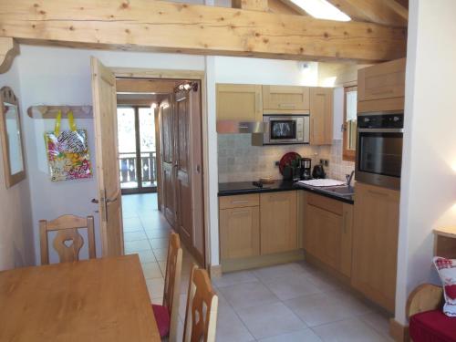 cocina con armarios de madera y mesa de madera en Alpine Lodge 6, en Les Contamines-Montjoie