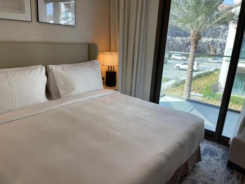 a bed in a hotel room with a large window at شقة فاخرة في فندق العنوان Two bedrooms apartment at address residences in Sharm