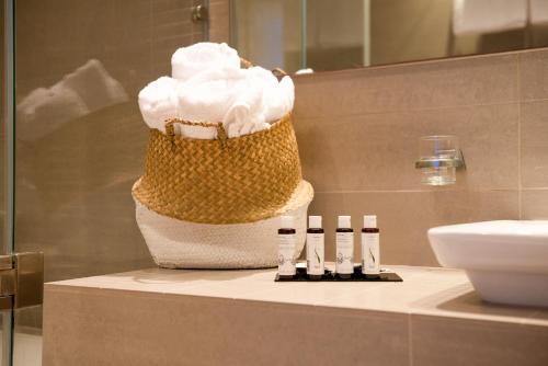 a bathroom with a basket of whipped cream on a counter at Iris Skiathos in Skiathos Town