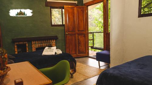 a bedroom with two beds and a table and window at Rancho Los Barriles in Acaxochitlán