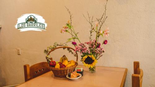 a table with a basket of fruit and flowers on it at Rancho Los Barriles in Acaxochitlán