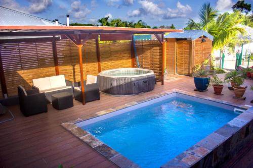 a swimming pool on a deck with a hot tub at Les Bougainvilliers Tropicaux in Sans Pareil