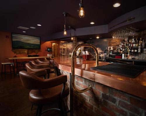 un bar con taburetes de cuero en un restaurante en The Horton Hotel, en Boone