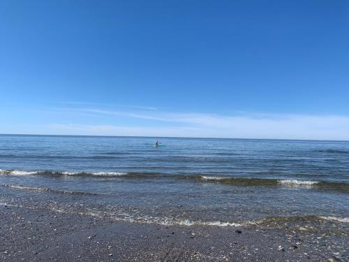 una persona está en el agua en la playa en Les studios de la mer, en Matane