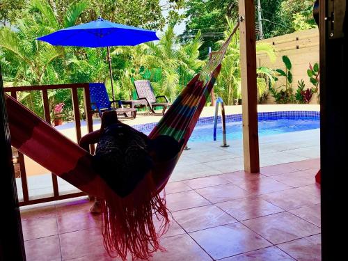 a person laying in a hammock next to a pool at Ocean Melody 3 in Uvita
