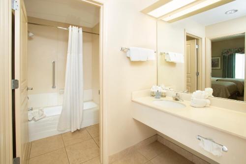 a bathroom with a shower, sink, and toilet at Hawthorn Suites by Wyndham Lake Buena Vista, a staySky Hotel & Resort in Orlando