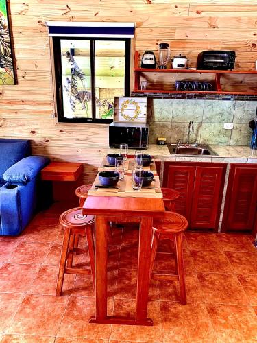 a kitchen with a wooden table with wine glasses on it at Ocean Melody 3 in Uvita