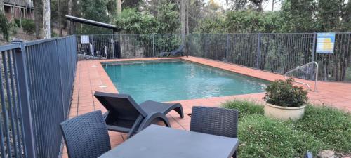 a small swimming pool with chairs and a table at Cypress Lakes Villa Domenica in Pokolbin