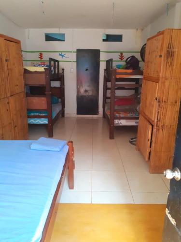 a room with a bed and some wooden cabinets at Palomino Hostel in Palomino