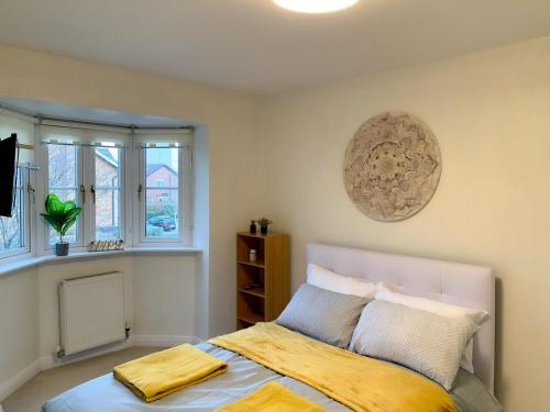 Un dormitorio con una cama con una manta amarilla. en Spacious and amazing 4 bedroom detached house, en Mánchester
