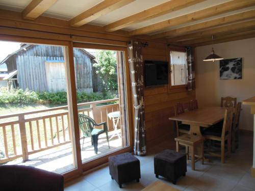 une salle à manger avec une table et un balcon dans l'établissement Alpine Lodge 4, aux Contamines-Montjoie