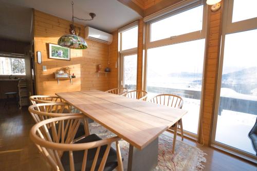 a dining room with a wooden table and chairs at The lakeview toya Shirokumanoyado in Lake Toya