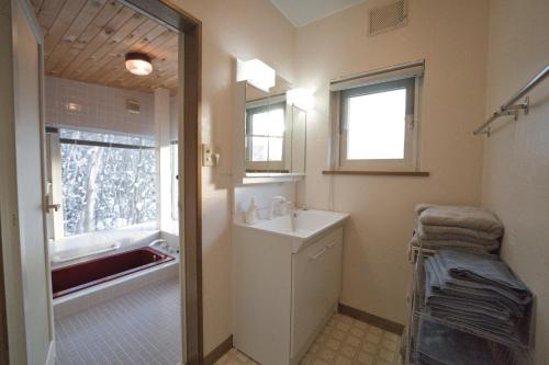 a bathroom with a sink and a mirror and a tub at The lakeview toya Shirokumanoyado in Lake Toya