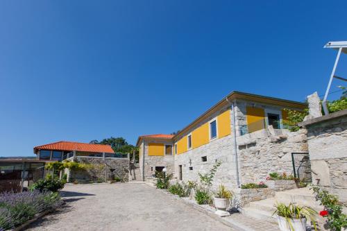 a stone house with a yellow at Quinta dos Fangueiros in Riba de Âncora