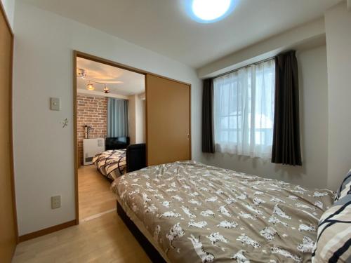 a bedroom with a bed and a large window at Near Nakajima park Close to Susukino Anbiennte 101 in Sapporo