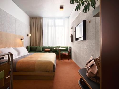 a hotel room with a bed and a couch and a table at Ace Hotel Sydney in Sydney