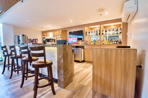 a bar with wooden bar stools in a restaurant at Commander Suites de Boracay in Boracay