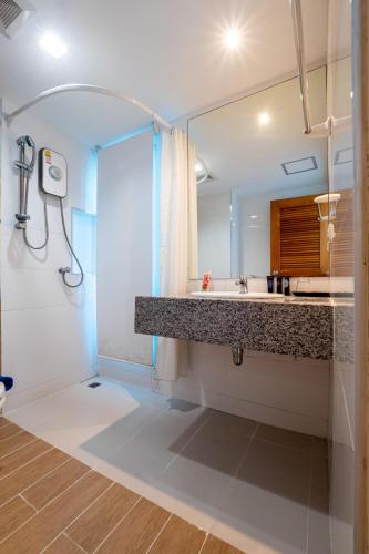 a bathroom with a shower and a sink and a mirror at By Dee at Jomtien in Jomtien Beach