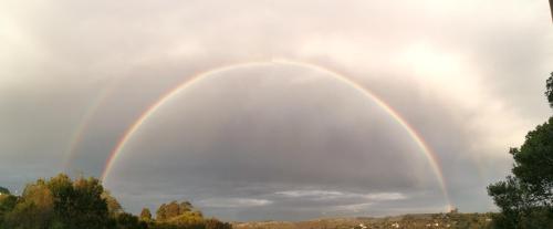 two double rainbow in the sky over a city at LeBruBi in Villa Serrana