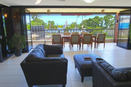 a living room filled with furniture and a large window at Cairns Aquarius in Cairns