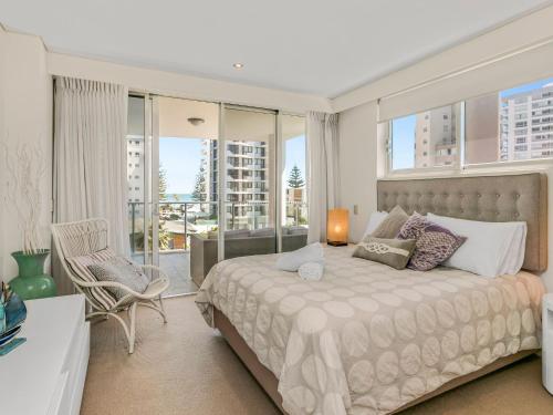 Un dormitorio con una cama grande y un balcón. en Eden Apartments Unit 401, en Gold Coast