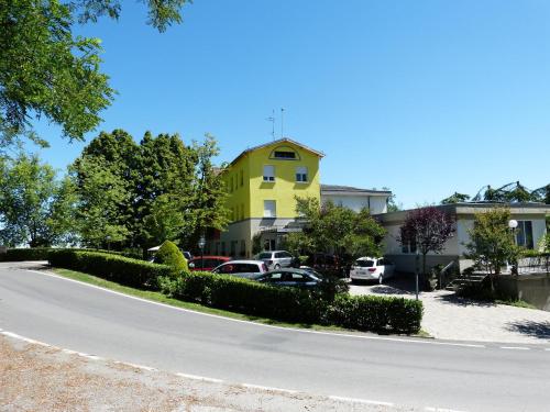 a yellow house with cars parked in a parking lot at Park Hotel Fantoni in Tabiano