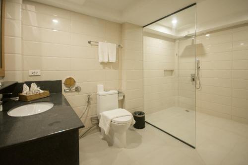 a bathroom with a shower and a toilet and a sink at Commander Suites de Boracay in Boracay