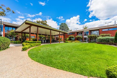 a building with a green lawn in front of it at Forrest Hotel & Apartments in Canberra