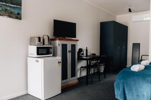 a room with a bed and a microwave and a table at Port Albert Motel in Port Albert