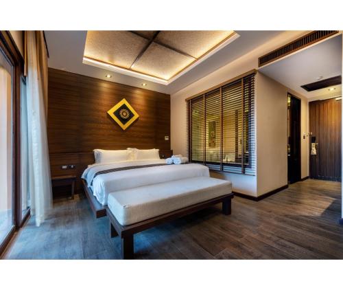 a bedroom with two beds and a large window at Nirvana Beach Resort, Koh Lanta SHA Extra Plus in Ko Lanta