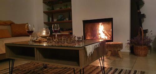 a living room with a fireplace and glasses of wine at The Mountain House in Ktima