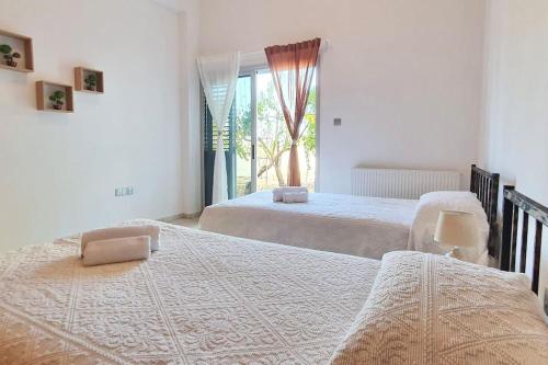 a bedroom with two beds and a window at The Mountain House in Ktima