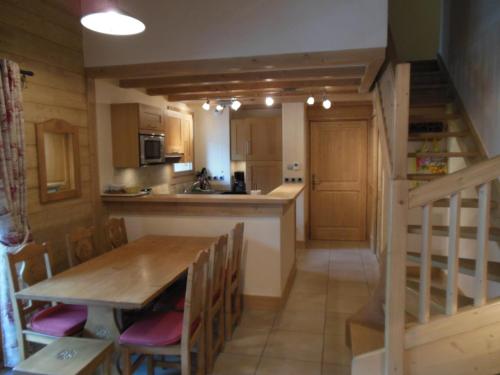 une cuisine et une salle à manger avec une table et un escalier dans l'établissement Alpine Lodge 9, aux Contamines-Montjoie