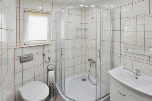 a bathroom with a shower and a toilet and a sink at Cottage by Lake Ostrowieckie with Private Beach in Kosierzewo