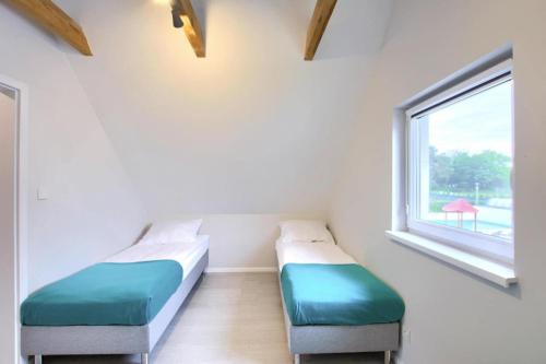 two beds in a room with a window at Apartment in Rogowo near Baltic Sea Beach in Rogowo