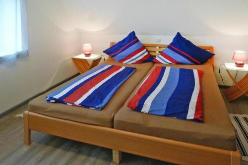 a bed with two pillows on it in a room at Holiday Apartment An der Meiße, Bergen in Bleckmar