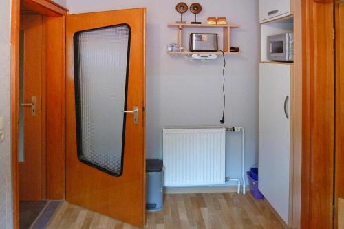 una puerta de madera con un espejo en una habitación en Holiday Apartment An der Meiße, Bergen, en Bleckmar