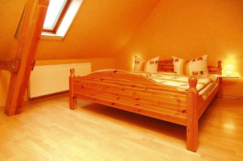 a bedroom with a wooden bed in a attic at Apartment, Parmen near Feldberg in Parmen