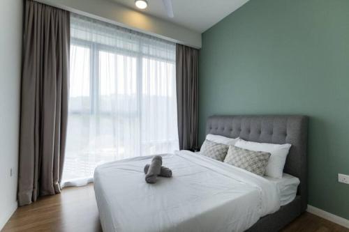 un osito de peluche sentado en una cama con una ventana en Mountain View 2 room KL East Mall 4pax NEW, en Kuala Lumpur