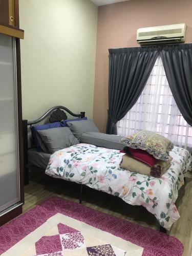 a bedroom with a bed and a window at Homestay Islam Bandar Tasik Puteri Rawang in Rawang