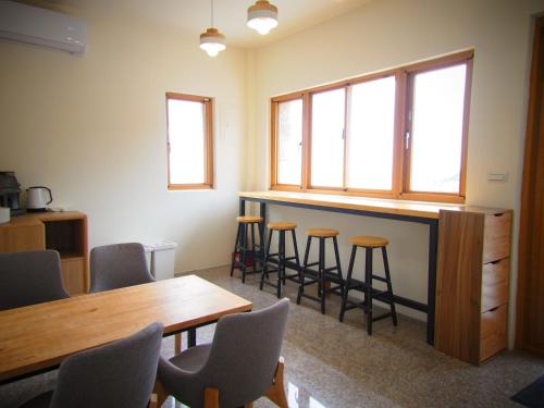 una stanza con bar con sedie e tavolo di Mulight B&B a Nangan