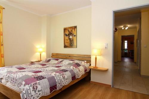 ein Schlafzimmer mit einem Bett und zwei Lampen sowie einen Flur in der Unterkunft Apartment Villa Sonja, Zingst in Zingst