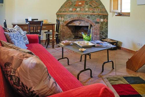 ein Wohnzimmer mit einem roten Sofa und einem Kamin in der Unterkunft Holiday home, Castiglione di Sicilia in Castiglione di Sicilia