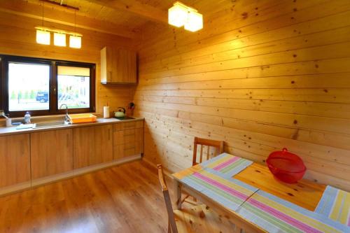 a wooden kitchen with a table and a sink at Holiday resort, Grzybowo in Grzybowo