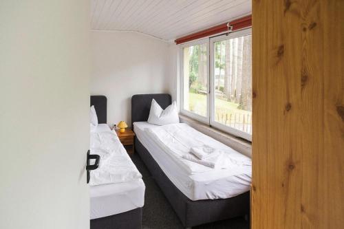 two beds in a room with a window at Ferienhaus Vieting direkt am Eldeufer in Parchim in Parchim